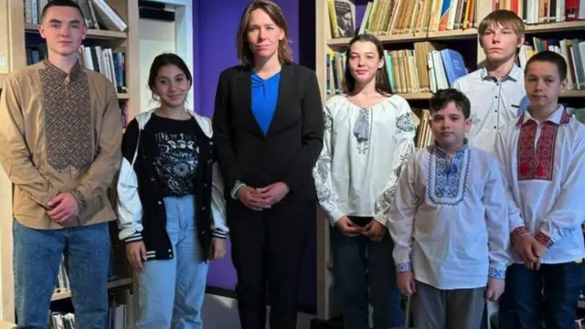 The six children stand with the Dutch foreign minister