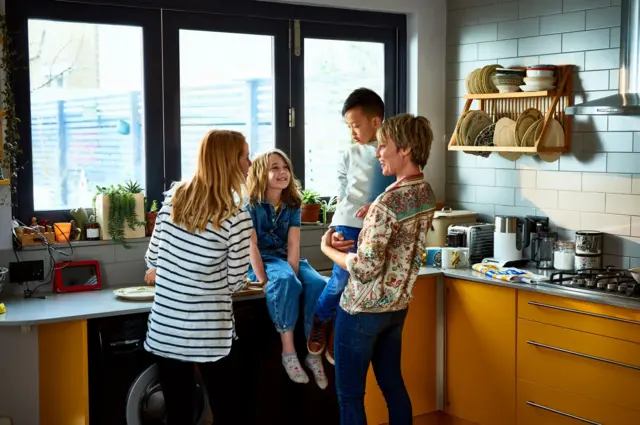 Una pareja con sus dos hijos en la cocina