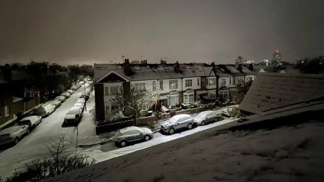 Ulica i domy w Eailng, dzielnicy Londynu, pokryte warstwą śniegu w nocy