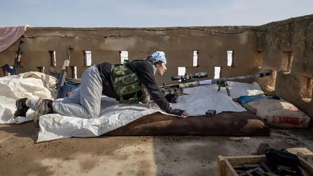 24 Ocak'ta Haseke'de çekilen fotoğrafta bir Kadın Savunma Birlikleri (YPJ) mensubu görülüyor. YPJ üyesi, uzun namlulu bir silahla yatarak nöbet tutuyor.