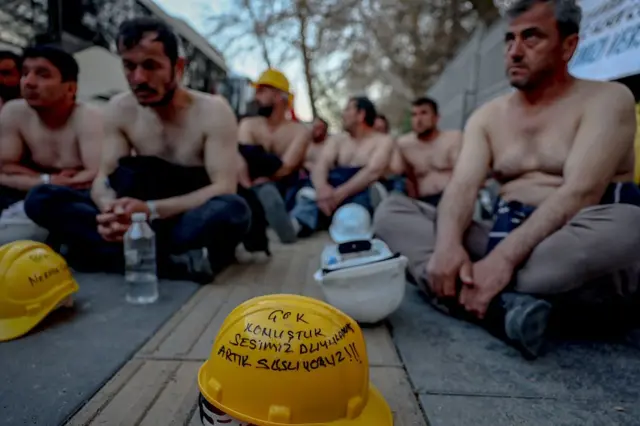 Eylem sırasında yerde duran bir baretin üzerinde "Çok konuştuk ama kimse dinlemedi, şimdi susuyoruz" yazılı bir slogan yer alıyor.