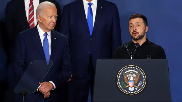 Joe Biden ao ladosport bet 88Volodymyr Zelensky, que está discursandosport bet 88um púlpito.