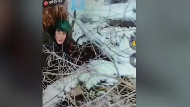 Північнокорейський солдат лежить на снігу під деревом. Вид з об'єктиву дрона 