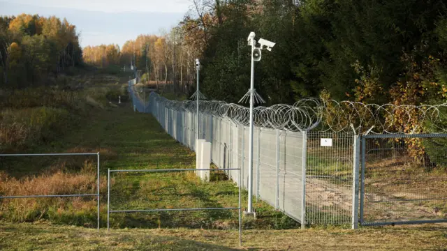 Ogrodzenie graniczne między Litwą a Rosją widoczne na obszarze Przełęczy Suwalskiej, korytarza lądowego na wspólnej granicy Litwy, Polski i Rosji, otoczonego rosyjską eksklawą Kaliningradu od północnego zachodu i sojuszniczą Białorusią od południowego wschodu. Pas lądu o długości zaledwie 104 kilometrów (65 mil) stanowi jedyne połączenie lądowe między państwami bałtyckimi a europejskimi członkami NATO. Przełęcz Suwalska jest uważana za wrażliwą, ponieważ inwazja odcięłaby państwa bałtyckie od reszty sojuszu, na potrójnej granicy w pobliżu Bolci, Polska, 17 października 2022 r. REUTERS/Kacper Pempel