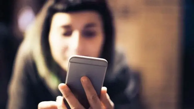 मोबाइल इस्तेमाल करती महिला