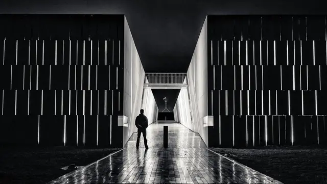 Una image en blanco y negro de un hombre con el Parlamento australiano al fondo.