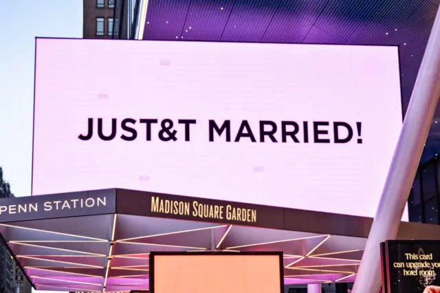 Inyubako ya Madison Square Garden igaragaza urumuri rw'iroza ruriho amagambo yo mu Cyongereza 'JUST&T MARRIED', mu bukwe bwa Taylor Swift naTravis Kelce, i New York, muri Amerika, ku itariki ya 3 Nyakanga (7) mu 2026.
