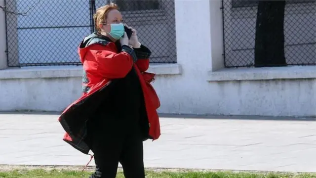 Žena sa maskom na praznoj ulici