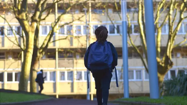 Niña camina sola al colegio.