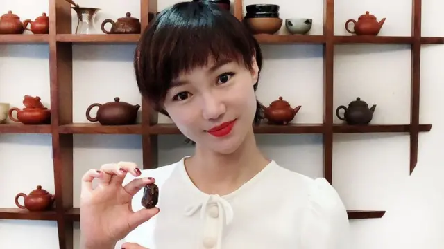 Una mujer sostiene a la serpiente bebé preservada en ámbar.