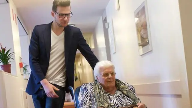 Jurrien Mentink empujando una residente en silla de ruedas