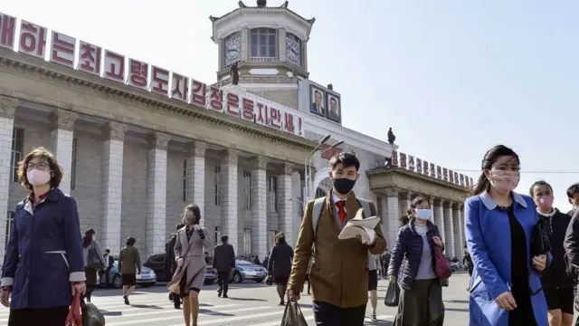 북한 평양시 평양역 앞을 보호용 안면 마스크를 쓴 시민들이 걷고 있다