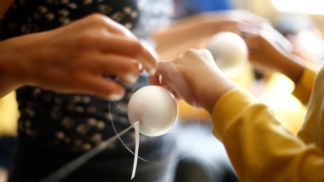 Manos tocando pelotas que representan planetas