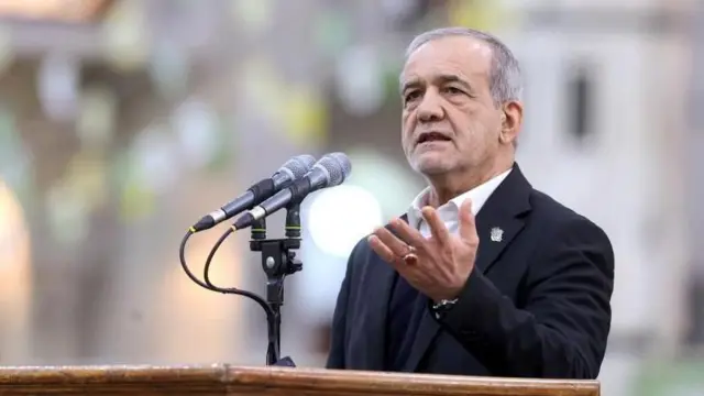 屋外で演台のマイクに向かって話すスーツ姿で白髪のペゼシュキアン氏