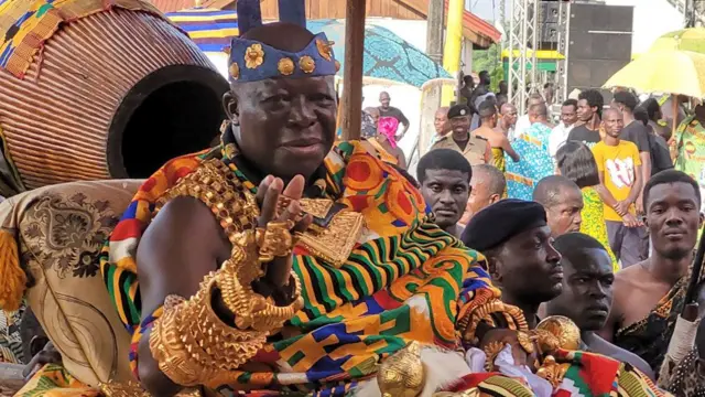 King Osei Tutu II is paraded on his palanquin through the crowd, weighed down by magnificent gold jewellery