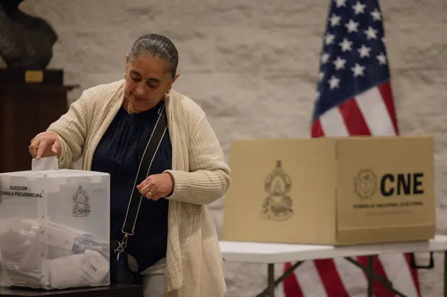Una mujer votando en un colegio de votación en EE.UU.