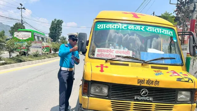 गाडी चालकको कागजपत्र हेर्दै ट्राफिक प्रहरी