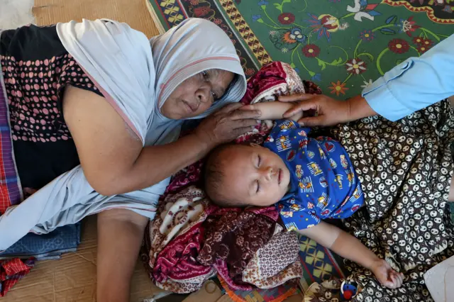 Pengungsi bencana banjir luapan Sungai Tingkeum beristirahat bersama anaknya di posko pengungsian Aceh Masjid Jamie Al-Itiqamah, Ulee Tutue, Bireuen, Aceh, Senin (1/12/2025).