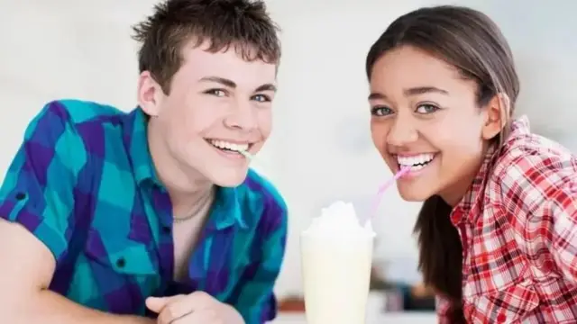 Umukobwa n'umuhungu basangira Ice cream mu kirahure kimwe bishimye