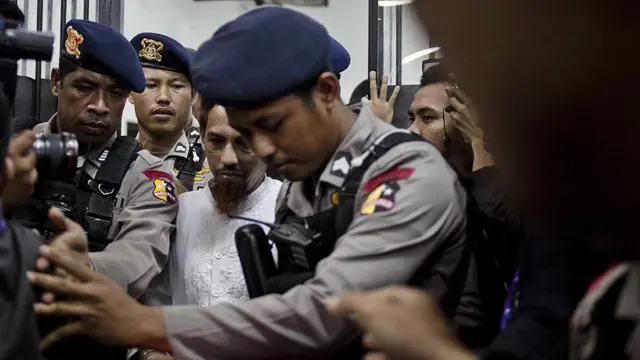 Umar Patek dikawal oleh polisi saat meninggalkan pengadilan selama sidang vonis bom Bali pada 21 Juni 2012 di Jakarta.