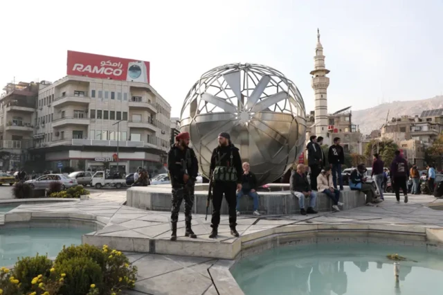 مردان مسلح در میدان مقابل بانک مرکزی سوریه، یک روز بعد از سقوط بشار اسد 