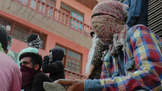 पत्थर हाथ में लिए एक युवक