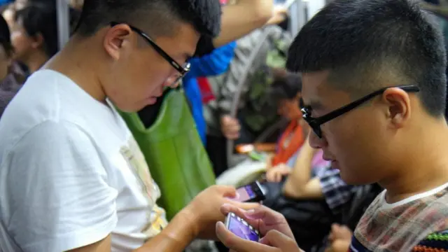 Chineses mexendo nos celulares no metrô