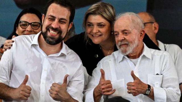 Guilherme Boulos e Lula fazendo sinaljogar na mega da virada pelo celularpositivo com os dedos