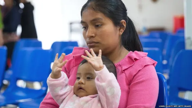 A Guatemalan woman and her infant daughter seeking asylum sit at a Catholic Charities relief center on Sunday, June 17, 2018 in McAllen, Texas. -
