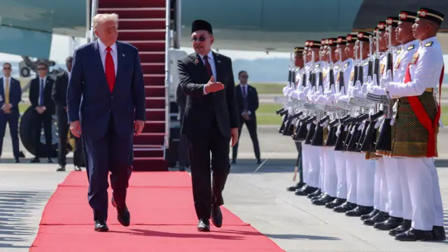Дональд Трамп идет по красной ковровой дорожке после прилета в Куала-Лумпур 