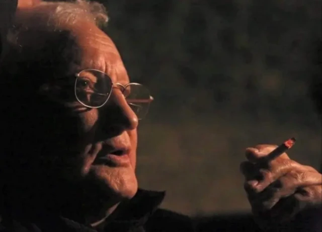 زریاب در حال کشیدن سیگرت و عینکی در چشم دارد 