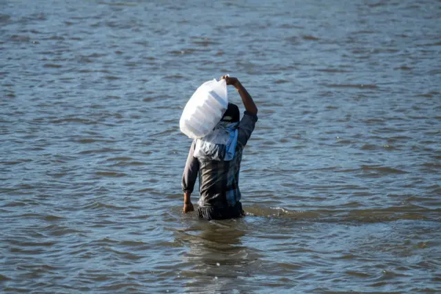 ၂၀၂၁ ခုနှစ် ဒီဇင်ဘာလတုန်းက သောင်းရင်းမြစ်ကို ဖြတ်သန်းစစ်ရှောင်သူတွေကို ကူညီနေတဲ့ မြင်ကွင်း 