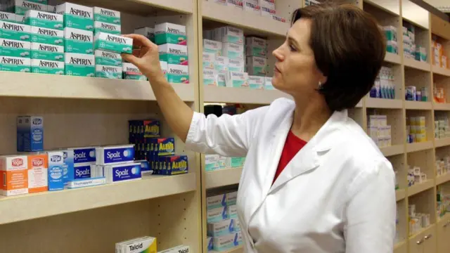 طبيبة أمام مجموعة من علب أقراص الأسبرين