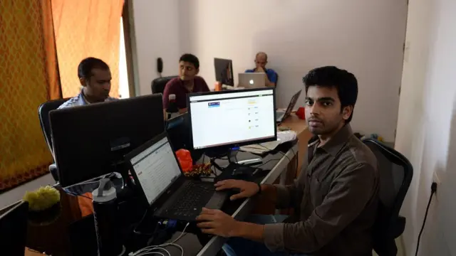 تقنيون أمام أجهزة كمبيوتر