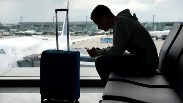 Пассажир в аэропорту с телефоном