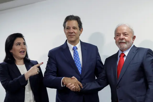 Fernando Haddad, ao ladoestatísticas apostas esportivasSimone Tebet, cumprimenta Lula; todos com expressãoestatísticas apostas esportivasfelicidade