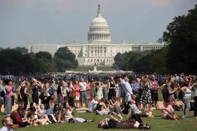 ABD’nin başkenti Washington’da bir milli park National Mall’da güneş tutulmasını izleyen gençler.