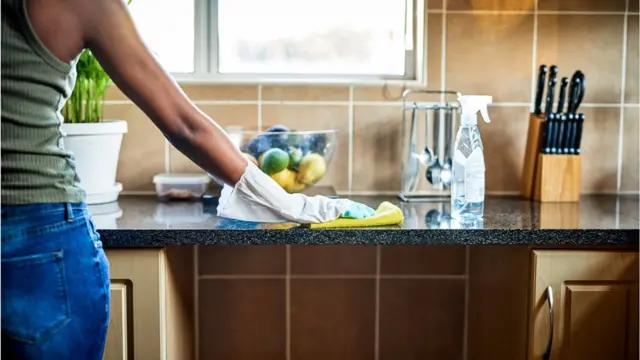 Une main qui nettoie le plan de travail