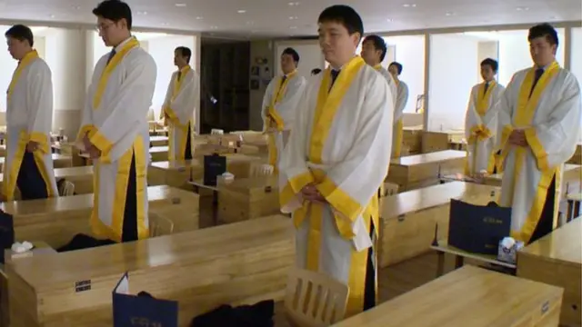 Pacientes del centro Hyowon de Seúl parados al lado de sus ataúdes de madera.