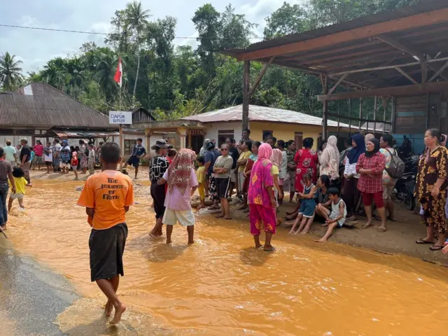 Sebagian warga berkumpul di tengah banjir.