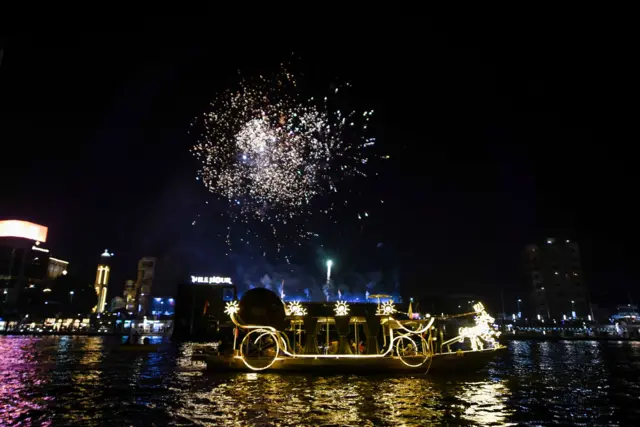 ألعاب نارية فوق صفحة النيل الذي تسير عليه مركب مضاءة يتقدمها ما يشبه الحصان