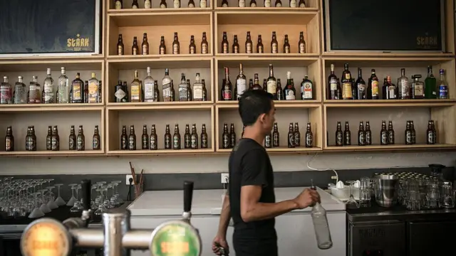 Seorang bartender berjalan sambil menyiapkan minuman di rumah bir Stark di Jalan Legian pada 16 April 2015 di Kuta, Bali