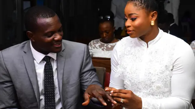 Christiana Alabi passe la bague au doigt de Kayode lors de la cérémonie de mariage.