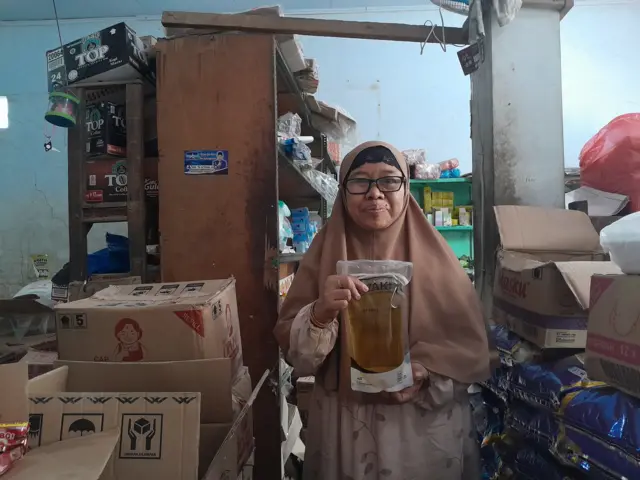 Ruliani, pedagang di Madura, Jawa Timur, mengatakan konsumen cenderung memilih membeli Minyakita dalam kemasan plastik atau pouch daripada botol.