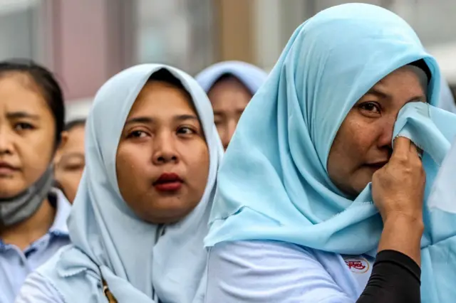 Seorang pekerja pabrik tekstil menangis saat mendengarkan pidato perpisahan saat PHK massal, di Sukoharjo, Jawa Tengah, pada 28 Februari 2025, setelah Mahkamah Agung negara itu menyatakan raksasa tekstil itu bangkrut karena gagal membayar utang dan menghentikan operasinya.