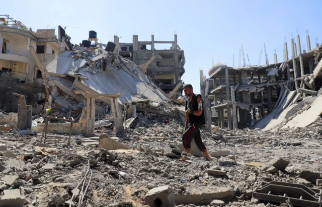 Un hombre camina entre escombros en Gaza