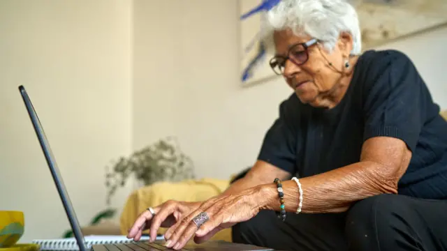 Mujer de edad avanzada con un computador.