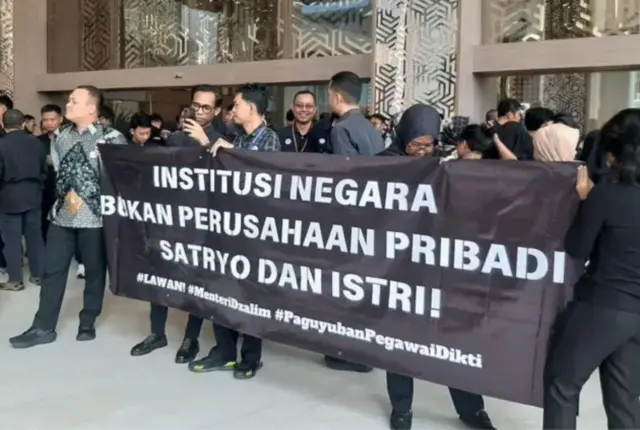 Salah satu spanduk demo ASN Kementerian Pendidikan Tinggi, Sains, dan Teknologi bertulisan: "Institusi negara bukan perusahaan pribadi Satryo dan istri."