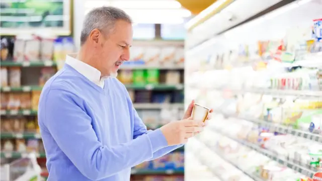 Homem verifica o rótulocomo apostar na roleta betanoum produto no supermercado