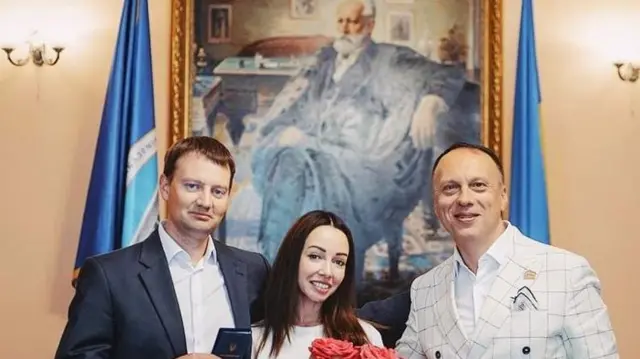 Ректор академии Максим Тимошенко с гостями учреждения на фоне большого портрета Чайковского